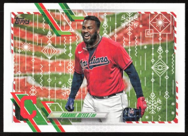 2021 Topps Holiday Franmil Reyes card, mid-swing in Cleveland Guardians uniform, festive design.