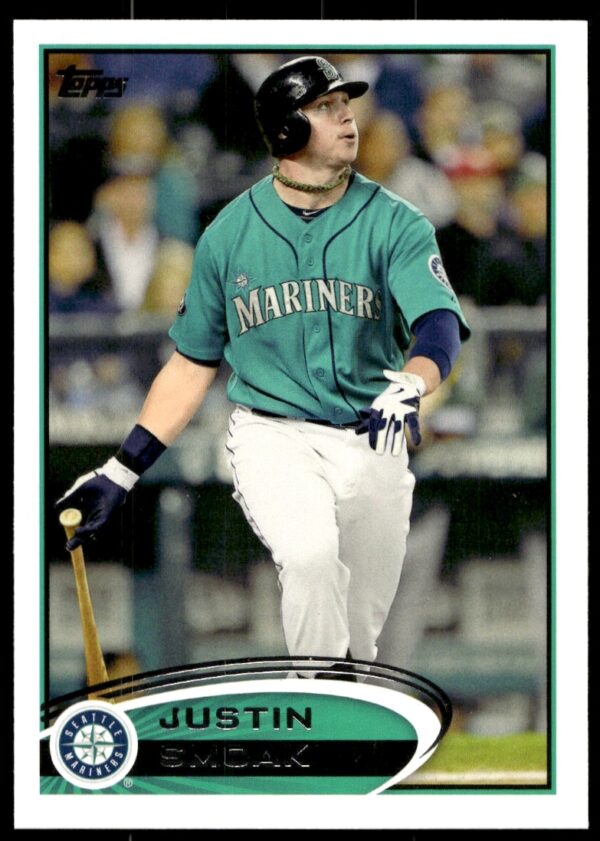 2012 Topps baseball card #627: Justin Smoak in Mariners uniform mid-swing, front view.