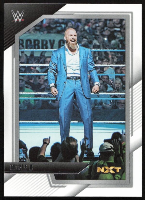 WWE NXT card featuring Triple H in blue suit, in-ring, with WWE and NXT logos.
