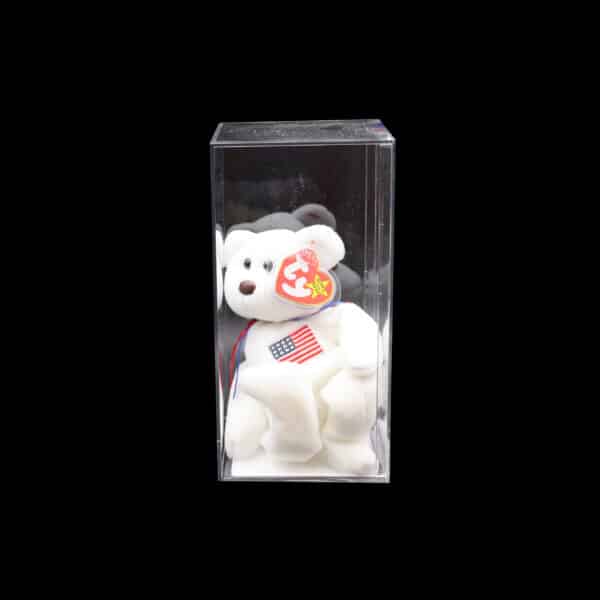 White Beanie Baby bear with American flag in clear box on black background.